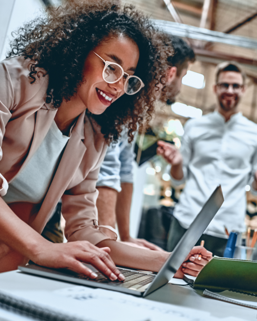 Femme souriante devant son ordinateur en open space - diagnostic RSE simple et efficace